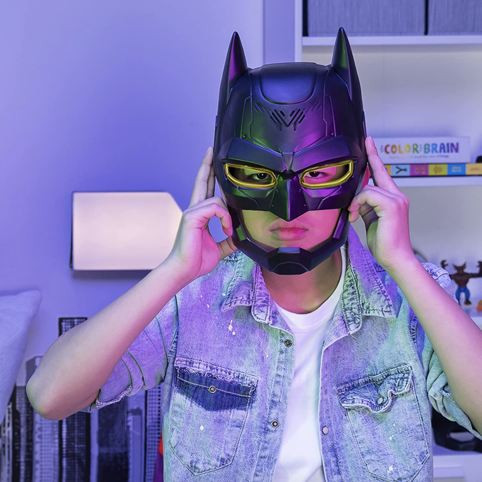 little boy wearing denim shirt and black Batman Voice Changing Mask (Photo via Amazon)