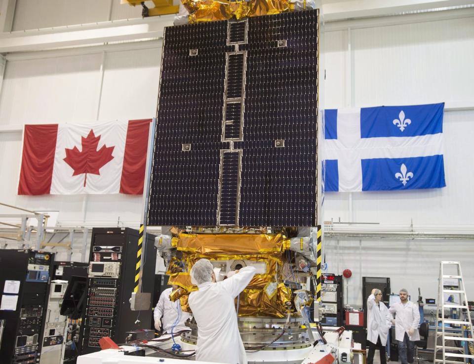 Technicians put the finishing touches on the second of three Radarsat Constellation Mission satellites at the MDA facility on June 21, 2018 in Montreal.  A Toronto-based investment firm has signed a $1 billion deal to buy the Canadian space technology company behind the Radarsat Earth observation satellites and the Canadarm robotic mechanisms on the International Space Station.