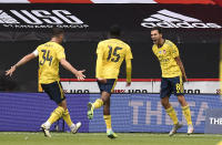 Arsenal's Dani Ceballos, right, celebrates with his teammates after scoring his side's second goal during the FA Cup sixth round soccer match between Sheffield United and Arsenal at Bramall Lane in Sheffield, England, Sunday, June 28, 2020. (Oli Scarff/Pool via AP)