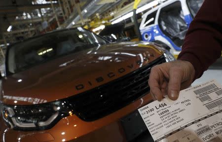 A worker holds a build card for a vehicle destined for China at the Jaguar Land Rover facility in Solihull, Britain, January 30, 2017. REUTERS/Darren Staples