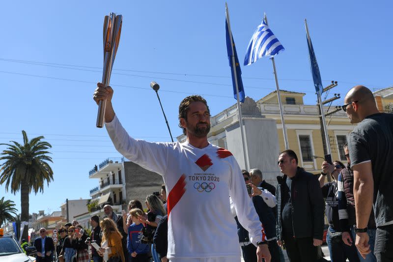 US actor Gerard Butler takes part in the Olympic flame torch relay for the Tokyo 2020 Summer Olympics