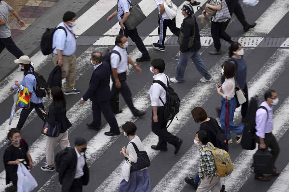 People wearing protective masks to help curb the spread of the coronavirus walk along a pedestrian crossing Wednesday, June 16, 2021, in Tokyo. The Japanese capital confirmed more than 500 new coronavirus cases on Wednesday. (AP Photo/Eugene Hoshiko)