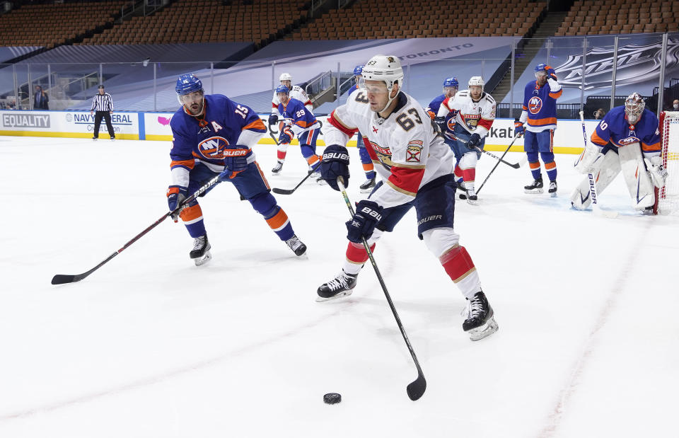 TORONTO, ONTARIO - AUGUST 01: Evgenii Dadonov #63 of the Florida Panthersand Cal Clutterbuck #15 of the New York Islanders skate in the second period of Game One of the Eastern Conference Qualification Round at Scotiabank Arena on August 01, 2020 in Toronto, Ontario.  (Photo by Mark Blinch/NHLI via Getty Images)