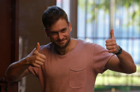 Pyotr Verzilov, one of four intruders affiliated to Russia's Pussy Riot protest group who were jailed for 15 days for staging a pitch invasion during the football World Cup final and were detained again after their release on July 30, gives a double thumb-up outside a court building in Moscow, Russia July 31, 2018. REUTERS/Tatyana Makeyeva