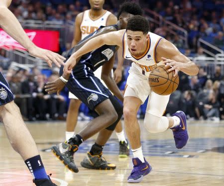 Dec 26, 2018; Orlando, FL, USA; Phoenix Suns guard Devin Booker (1) drives through the lane past Orlando Magic forward Jonathan Isaac (left center) during the first quarter at Amway Center. Mandatory Credit: Reinhold Matay-USA TODAY Sports