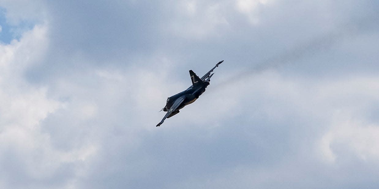 A Russian Su-25 warplane, with a Z on its tail fin, flies against a cloudy blue sky above Olenivka, Donetsk, Ukraine, on July 29, 2022