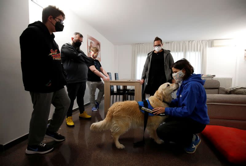 Meritxell Arias, dog-assisted intervention technician and AAS DISCAN founder, salutes dog assistant Niko during her visit to Hector Aguera and family in Terrassa