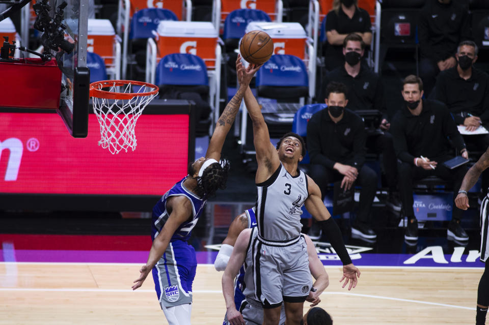 Sacramento Kings forward Marvin Bagley III, left, reaches for a rebound with San Antonio Spurs forward Keldon Johnson (3) during the first quarter of an NBA basketball game in Sacramento, Calif., Friday, May 7, 2021. (AP Photo/Hector Amezcua)