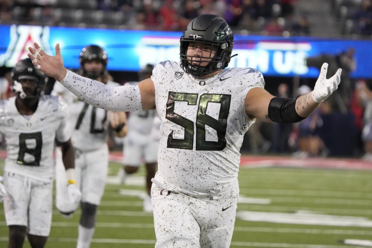 Oregon defensive lineman Jackson Powers-Johnson holds his arms out.