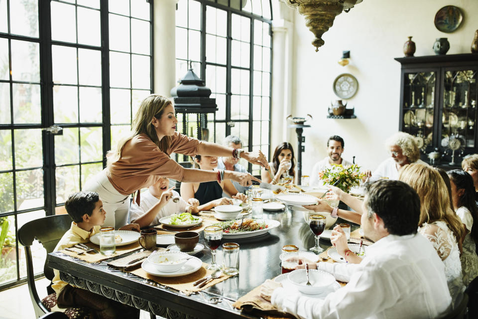 A group of people sat around a table having a meal or dinner party