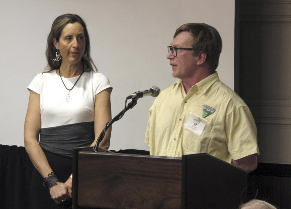 In this Monday, April 8, 2019, photo Mark Hall, right the U.S. Bureau of Land Management's field manager in Winnemucca, speaks as Burning Man organizer Marmee Benson looks on during a public hearing in Sparks, Nev. Nearly 200 Burning Man backers packed a casino meeting room to mostly complain about new conditions and restrictions the government wants to place on the counter-culture festival in the northern Nevada desert. (AP Photo/Scott Sonner)