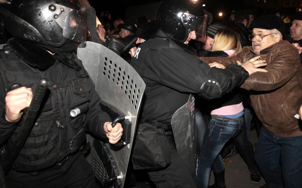 Ukrainian riot police officers block pro-Russian supporters of activist Pavel Gubarev during a rally in Donetsk, Ukraine, Thursday, March 6, 2014. Ukraine lurched toward breakup Thursday when lawmakers in Crimea unanimously declared they wanted to join Russia and would put the decision to voters in 10 days — and Russian lawmakers pushed a bill to facilitate a handover. (AP Photo/Sergei Chuzavkov)