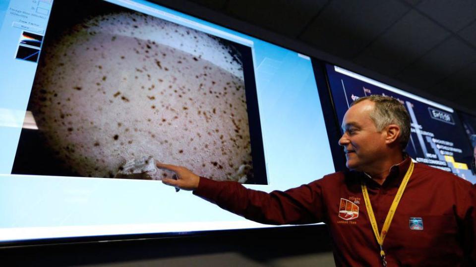 Un científico de la NASA señala en una pantalla el Insight Lander en una toma de Marte.