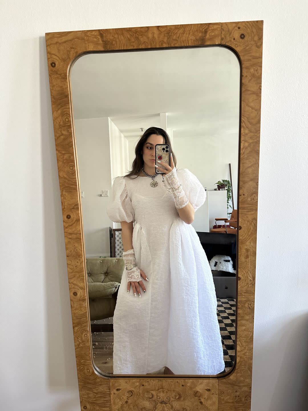 a person in a white dress taking a selfie in a mirror