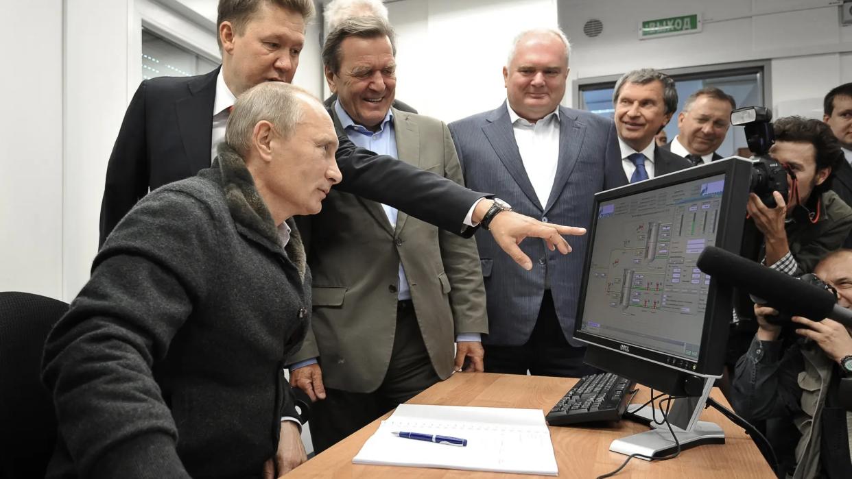  Vladimir Putin being shown something on a computer monitor. 