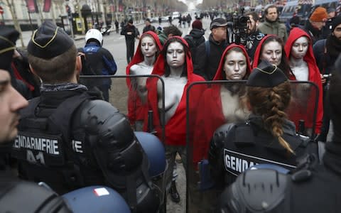 Five 'Mariannes' - the national symbol of the French Republic - confront the gendarmerie - Credit: VALERY HACHE/AFP/Getty Images