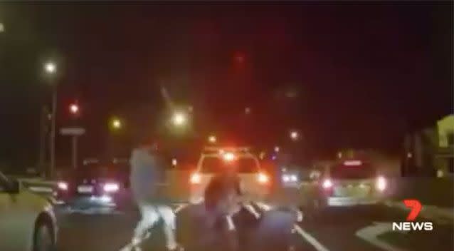 Two more men appear and the four involved in a scuffle in the middle of the road. Source: 7 News