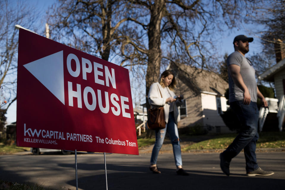 Potential home buyers walk past an 'Open House' sign displayed in the front yard of a property for sale. (Photo: Ty Wright/Bloomberg via Getty Images) 