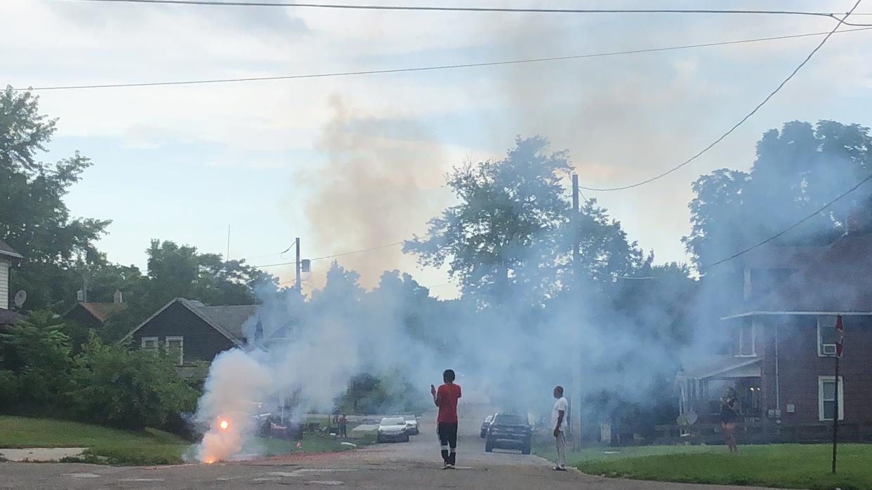 In Alliance, O., residents on South Webb Avenue watch and record as a series of small red firecrackers that stretch half of a block explode on Monday, July 3, 2023.