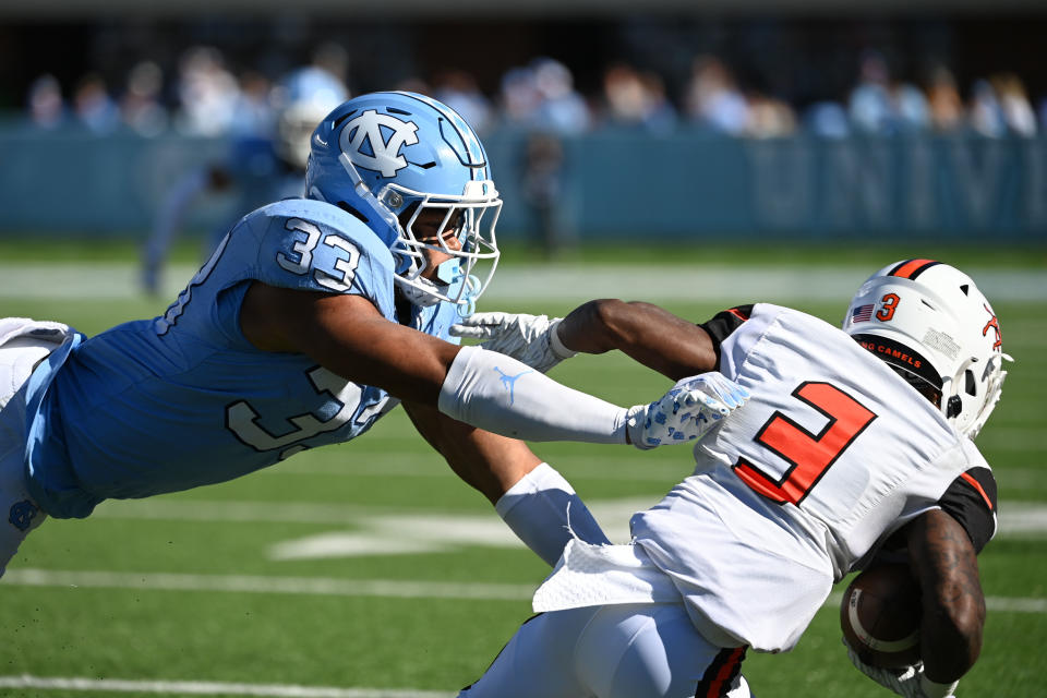 Nov 4, 2023; Chapel Hill, North Carolina, USA; Campbell Fighting Camels running back Tai Goode (3) is tackled by North Carolina Tar Heels linebacker Cedric Gray (33) in the third quarter at Kenan Memorial Stadium. Mandatory Credit: Bob Donnan-USA TODAY Sports