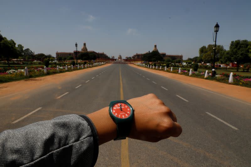 FILE PHOTO: A watch showing the time at noon, is displayed for a photo in front of an empty road at Rajpath, during the coronavirus disease (COVID-19) outbreak, in New Delhi