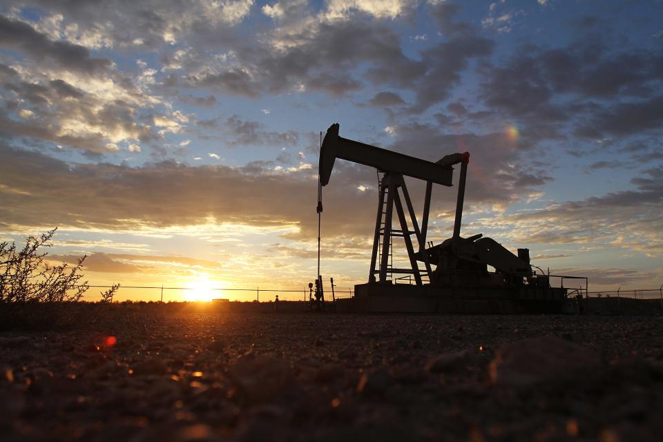 A pump jack is seen off County Road 6480 during sunset.
