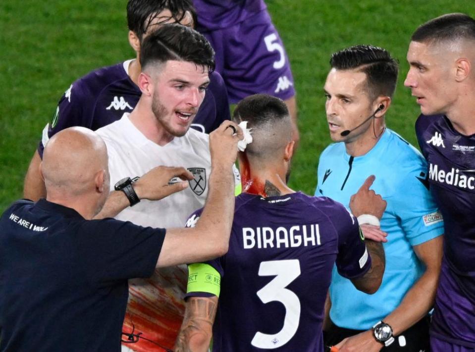 Fiorentina’s Cristiano Biraghi receives medical attention after being hit by an object thrown from the West Ham end