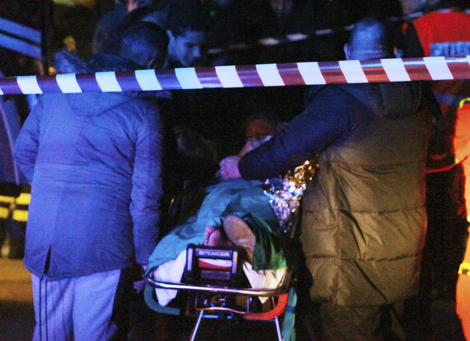 Rescuers assist an injured woman outside disco Lanterna Azzurra in Corinaldo, central Italy, Saturday, Dec. 8, 2018. A stampede at a rap concert in an overcrowded disco in central Italy killed five young teenagers and a woman who had accompanied her daughter to the event early Saturday, police said, adding that 59 people were injured. (AP Photo/Bobo Antic)