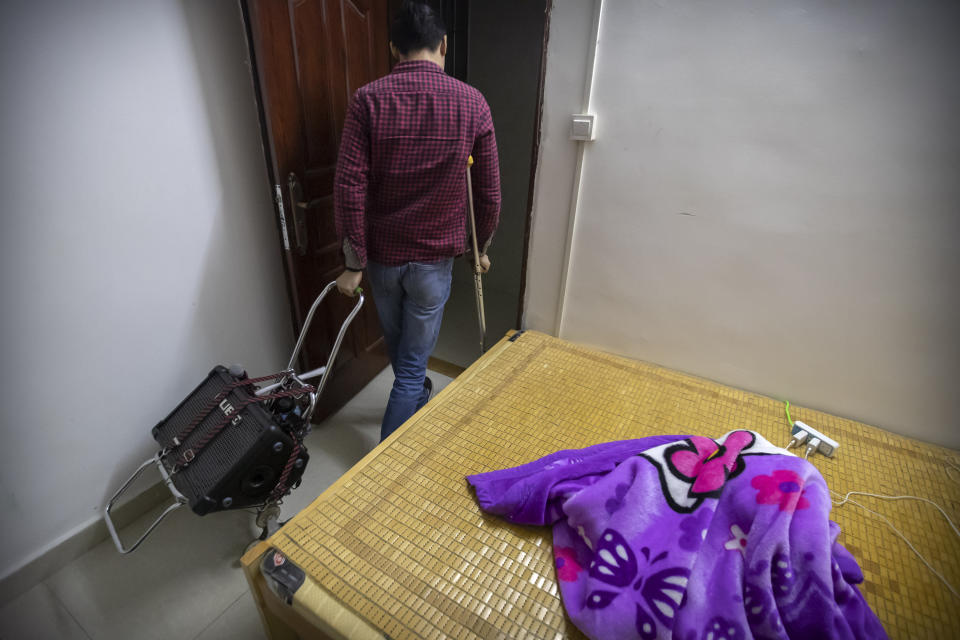 In this December 6, 2019, photo, Wu Yi, who has struggled with Oxycontin addiction, leaves his rented room to go sing songs for money at all night-restaurants and clubs in Shenzhen in southern China's Guangdong Province. Officially, pain pill abuse is an American problem, not a Chinese one. But people in China have fallen into opioid abuse the same way many Americans did, through a doctor's prescription. And despite China's strict regulations, online trafficking networks, which facilitated the spread of opioids in the U.S., also exist in China. (AP Photo/Mark Schiefelbein)