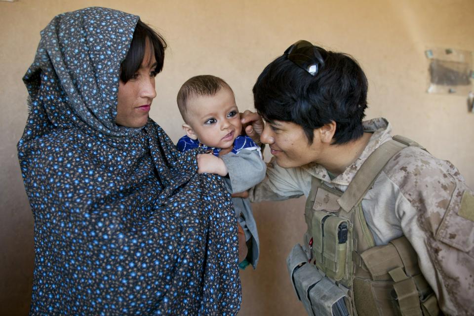 BOLDOC, AFGHANISTAN - NOVEMBER 23: (SPAIN OUT, FRANCE OUT, AFP OUT) Lance Corporal Luz Lopez, 21, a US Marine with the FET (Female Engagement Team) 1st Battalion 8th Marines, Regimental Combat team II plays with an Afghan baby during a village medical outreach on November 23, 2010 in Boldoc, in Helmand province , Afghanistan. There are 48 women presently working along the volatile front lines of the war in Afghanistan deployed as the second Female Engagement team participating in a more active role, gaining access where men can't. The women, many who volunteer for the 6.5 month deployment take a 10 week course at Camp Pendleton in California where they are trained for any possible situation, including learning Afghan customs and basic Pashtun language. (Photo by Paula Bronstein/Getty Images)