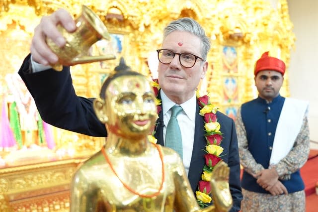 Sir Keir Starmer pours liquid over a golden statue