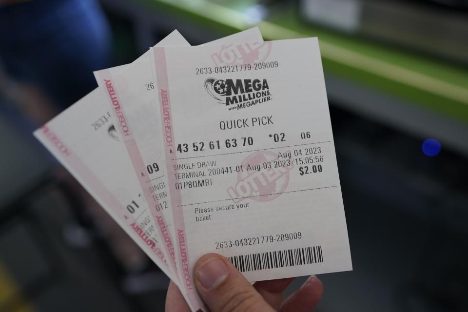 A Hoosier Lottery employee holds Mega Millions tickets at the Indiana State Fair in Indianapolis on Thursday. (Darron Cummings/AP)