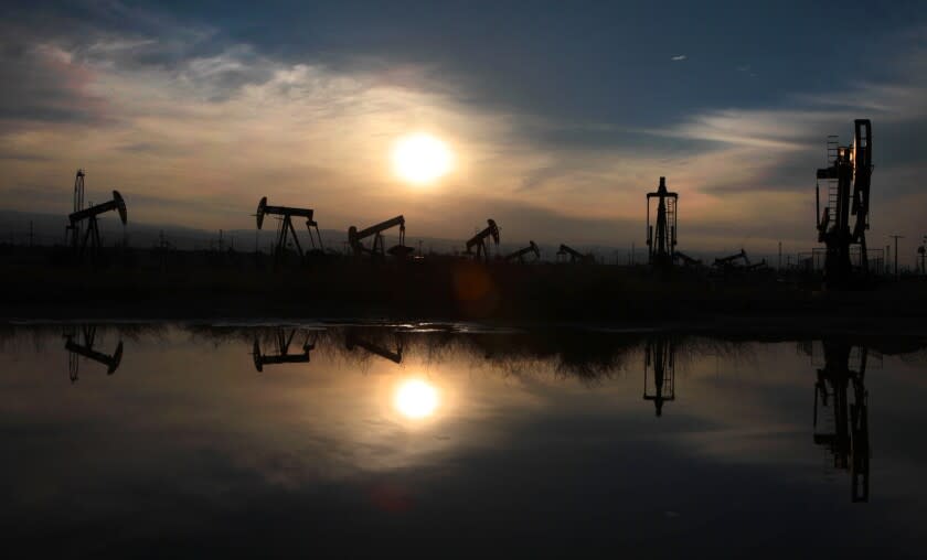 LOST HILLS, CA - MARCH 4, 2014: Oil pumps and equipment are reflected in a pool of water at the South Belridge oil field in Kern County. (Brian van der Brug / Los Angeles Times)