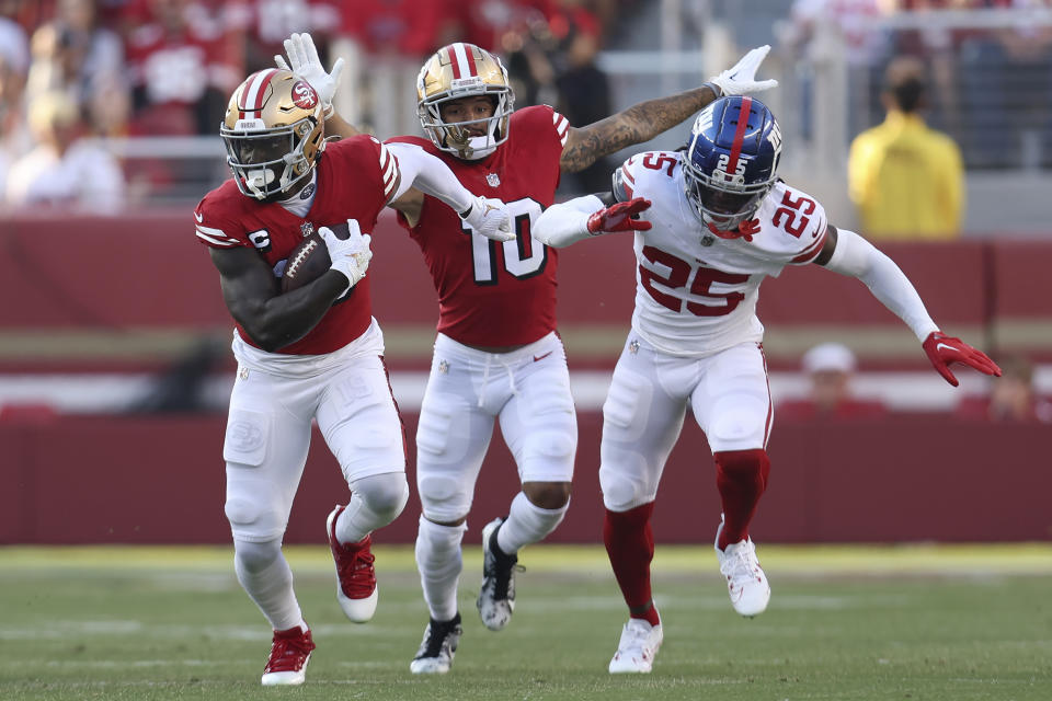 San Francisco 49ers wide receiver Deebo Samuel, left, runs in front of wide receiver Ronnie Bell (10) and New York Giants cornerback Deonte Banks (25) during the first half of an NFL football game in Santa Clara, Calif., Thursday, Sept. 21, 2023. (AP Photo/Jed Jacobsohn)