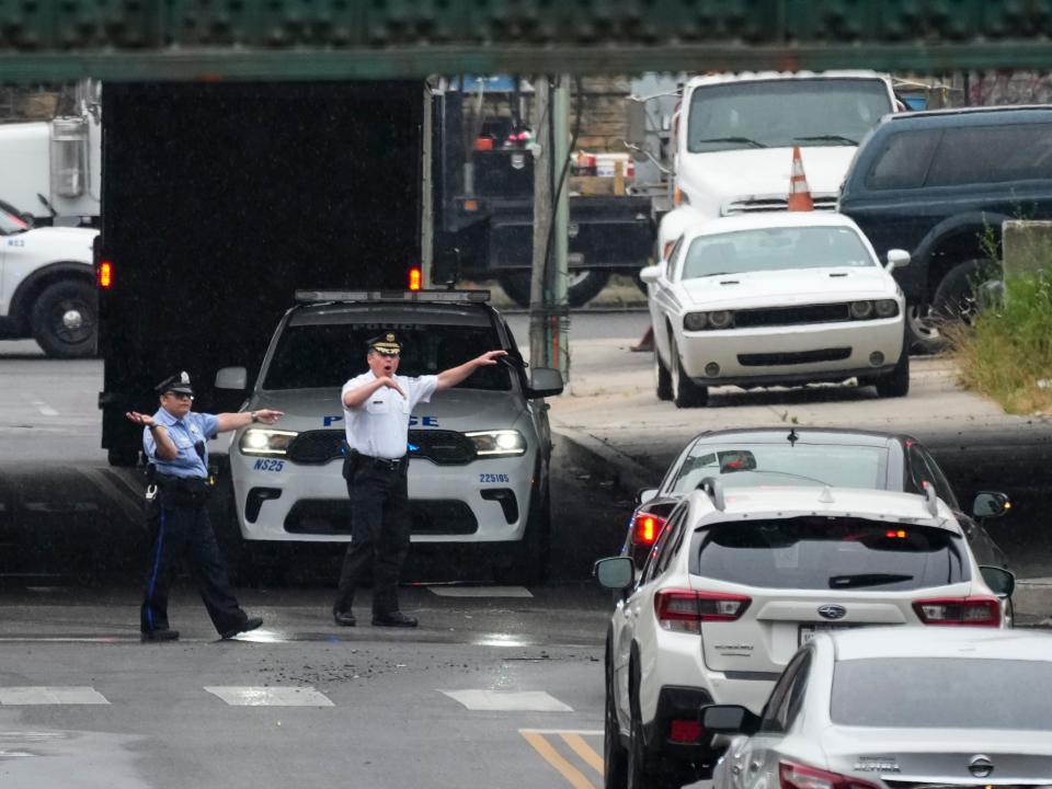 Officers direct traffic detoured in Philadelphia after the I-95 collapse.
