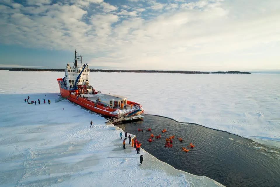 A Swedish icebreaker ship carves a path in the Arctic Sea.