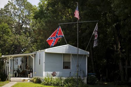 A Confederate battle flag (L) and a United States flag fly outside a home in Summerville, South Carolina June 22, 2015. REUTERS/Brian Snyder