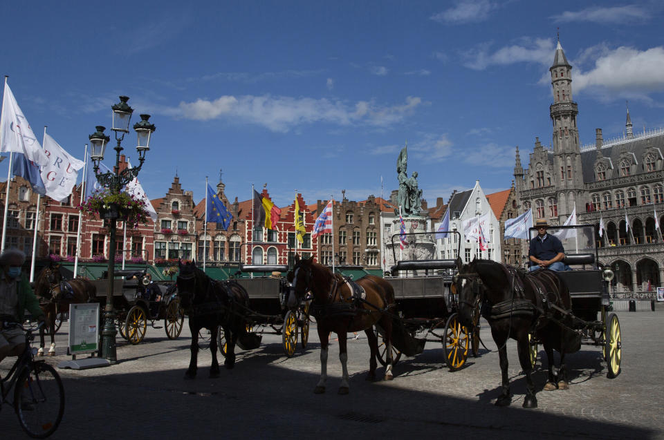 Horse and carriage tour operators wait in the center of Bruges, Belgium, Monday, Aug. 24, 2020. Europe’s leanest summer tourist season in history is starting to draw to a close, six months after the coronavirus hit the continent. COVID-19 might tighten its grip over the coming months, with losses piling up in the tens of billions of euros across the 27-nation European Union. In the Belgian city of Bruges, white swans instead of tourist boats rule the canals, hotels stand empty and museums count their losses. (AP Photo/Virginia Mayo)