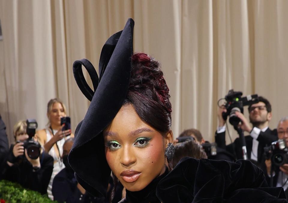 Normani wearing green eyeshadow and a black hat