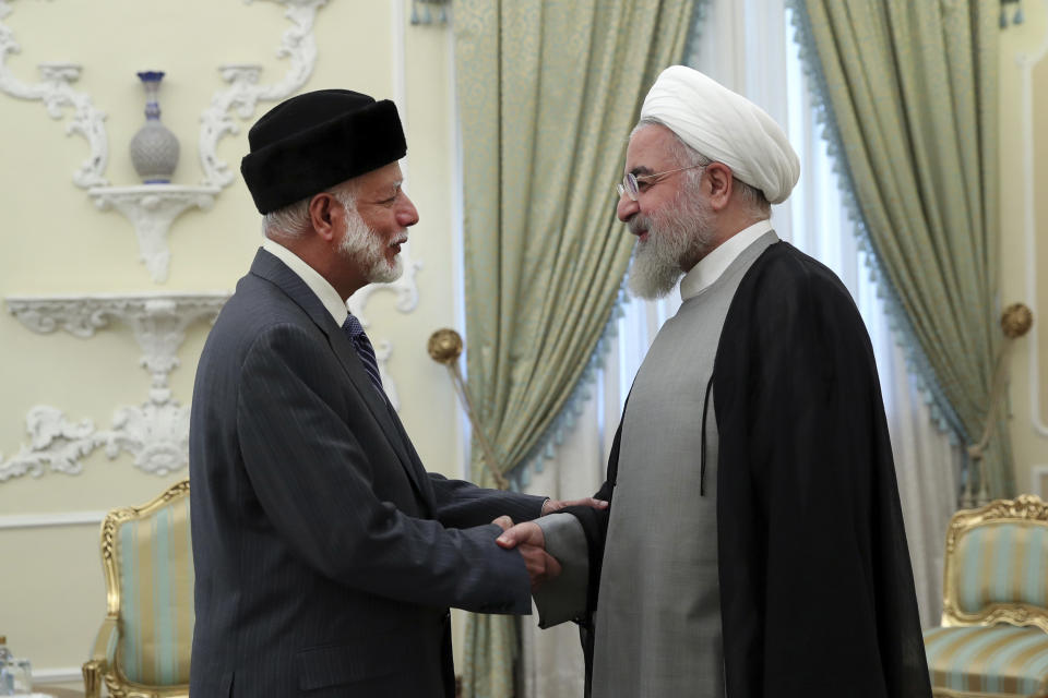 In this photo released by the official website of the office of the Iranian Presidency, Iranian President Hassan Rouhani, right, welcomes Omani Minister of State for Foreign Affairs Yusuf bin Alawi for their meeting in Tehran, Iran, Sunday, July 28, 2019. (Iranian Presidency Office via AP)