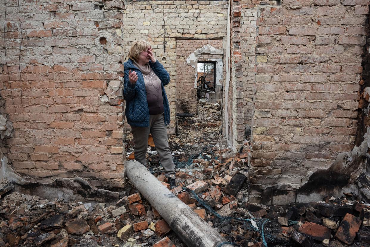 Inna, 53, cries inside her burnt house on April 25, 2022, in Ozera, Ukraine.