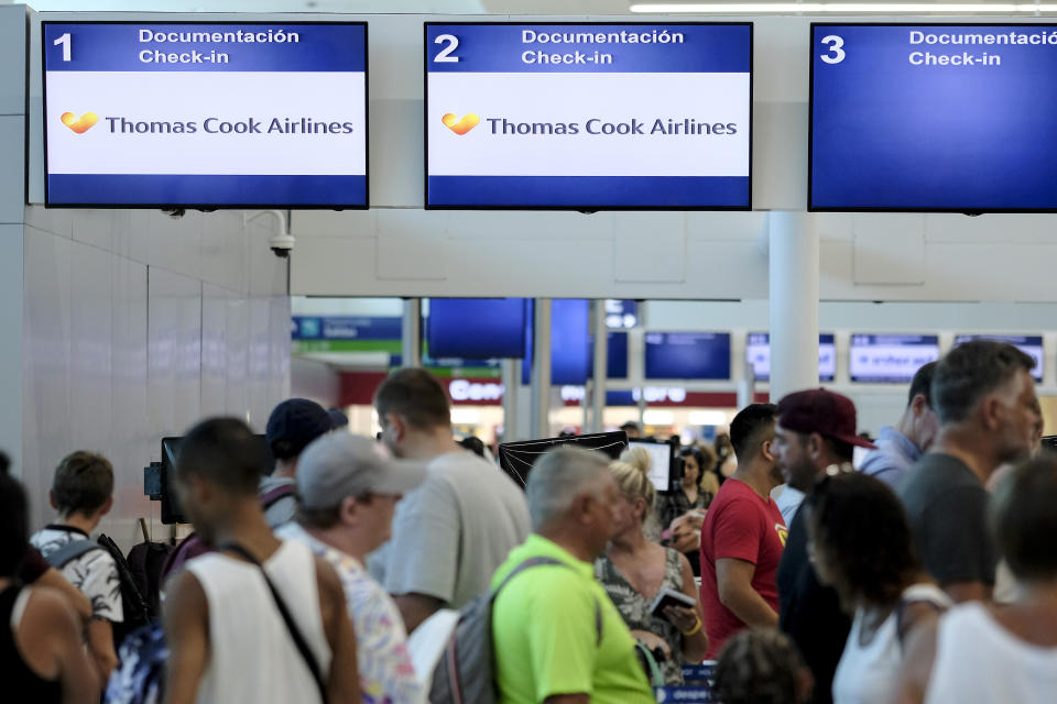 Stranded tourists line up in front of the Thomas Cook counter at the Cancun airport in Mexico, Monday, Sept. 23, 2019. British tour company Thomas Cook collapsed early Monday after failing to secure emergency funding, leaving tens of thousands of vacationers stranded abroad. (AP Photo/Victor Ruiz)