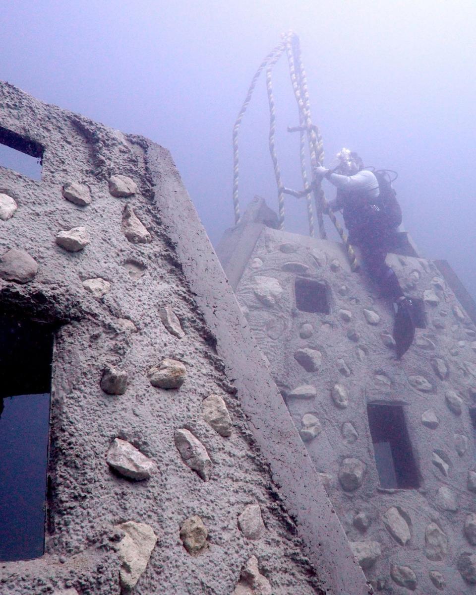 Divers inspect artificial reef structures that were deployed in the Gulf of Mexico recently.