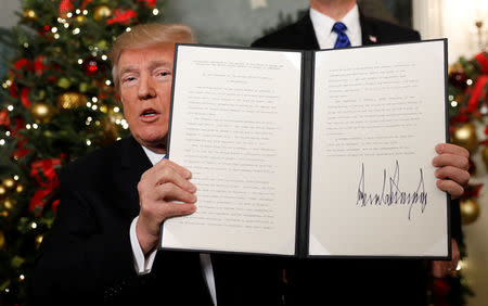 U.S. President Donald Trump holds up the proclamation that announces the United States recognizing Jerusalem as the capital of Israel and moving its embassy there, during an address from the White House in Washington, U.S., December 6, 2017. REUTERS/Kevin Lamarque