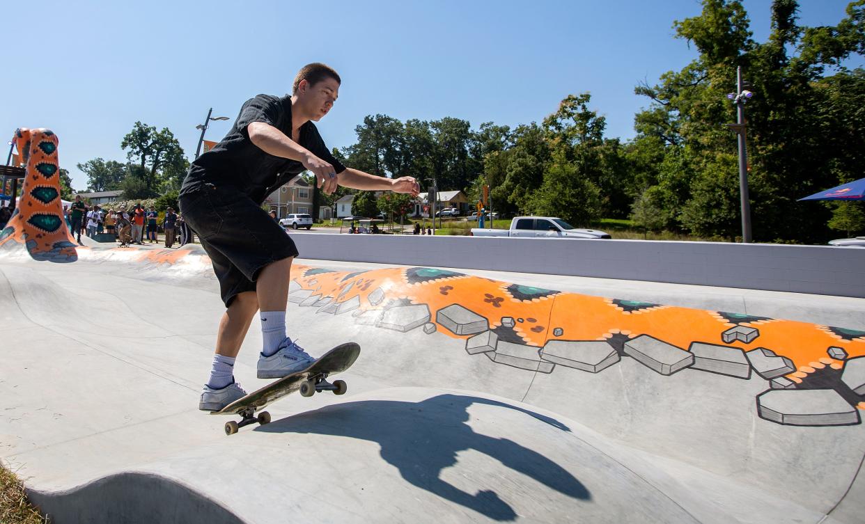 A skateboarder rolls over a speed bump in the new Cascades Trail Skateable Art Park during its grand opening on Wednesday, June 22, 2022 in Tallahassee, Fla. 