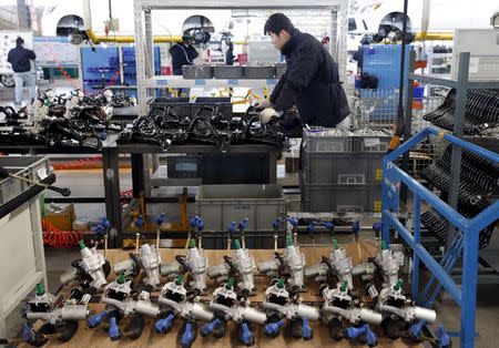 An employee works on an assembly line producing electronic cars at a factory of Beijing Electric Vehicle, funded by BAIC Group, in Beijing, China, January 18, 2016. REUTERS/Kim Kyung-Hoon