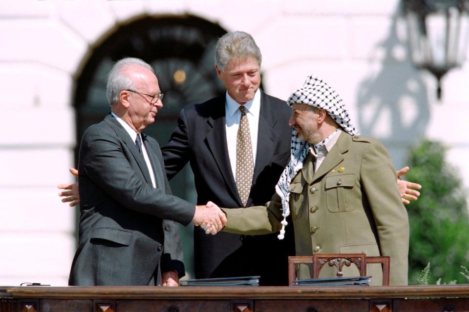 Israeli Prime Minister Yitzhak Rabin, left, shakes hands with PLO leader Yasser Arafat as U.S. President Bill Clinton looks on after the signing of the Oslo Accords in September 1993. <a href="https://www.gettyimages.com/detail/news-photo/president-bill-clinton-stands-between-plo-leader-yasser-news-photo/463575454" rel="nofollow noopener" target="_blank" data-ylk="slk:J. David Ake, Getty Images;elm:context_link;itc:0;sec:content-canvas" class="link ">J. David Ake, Getty Images</a>