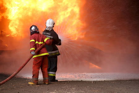 Firefighters try to put out the fire in an oil tank in the port of Es Sider, in Ras Lanuf, Libya January 23, 2016. REUTERS/Stringer