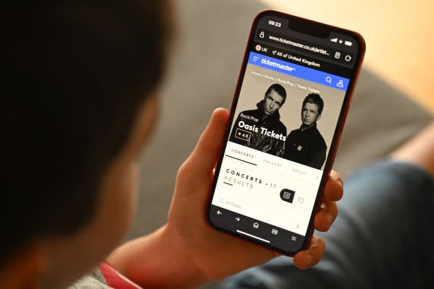 A fan uses a smartphone to access an online ticket sales website to purchase tickets for Oasis' "Live '25" tour taking place in 2025, at home in Marsden, England, on Aug. 31, 2024.  - Credit: OLI SCARFF/AFP/Getty Images