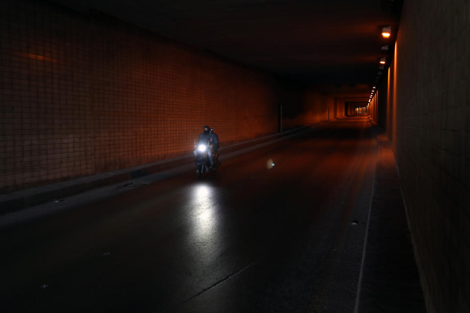 A food deliveryman on a scooter moves in an empty tunnel during a lockdown aimed at curbing the spread of the coronavirus, in Beirut Lebanon, Thursday, Jan. 21, 2021. Authorities on Thursday extended a nationwide lockdown by a week to Feb. 8 amid a steep rise in coronavirus deaths and infections that has overwhelmed the health care system. (AP Photo/Bilal Hussein)